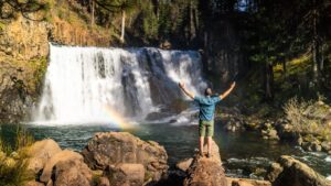 Ken Whiting standing in front of a waterfall in Mendocino California for an episode of Facing Waves