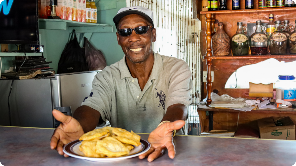 a photo of boyd's bakes owner plating bakes in dominica during a tv shoot of facing waves with ken whiting