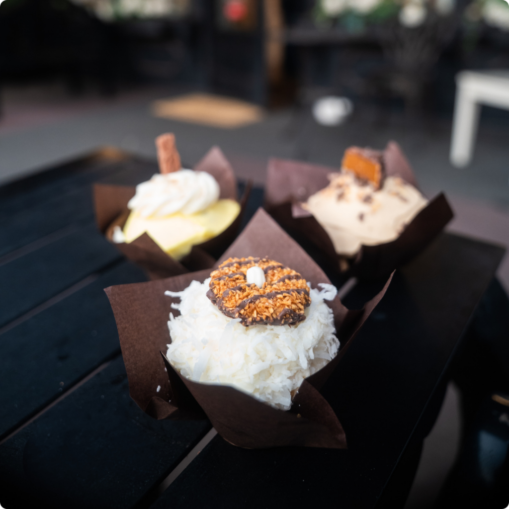 a high resolution photo of cupcakes on a table outside on a patio